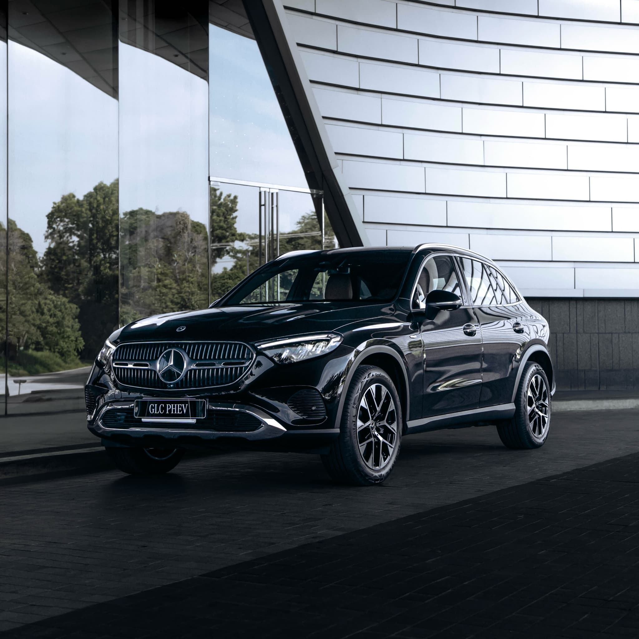 The full Mercedes-Benz GLC PHEV beside a modern facade